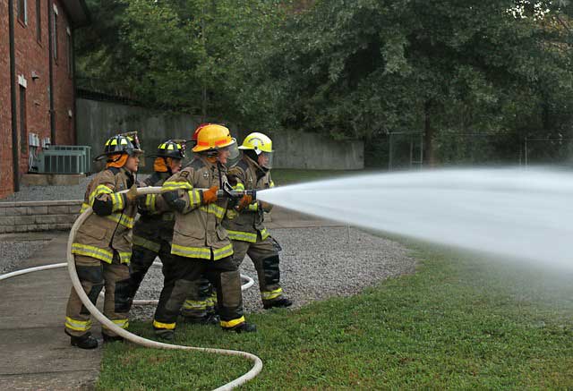 Firefighters holding a fire hose
